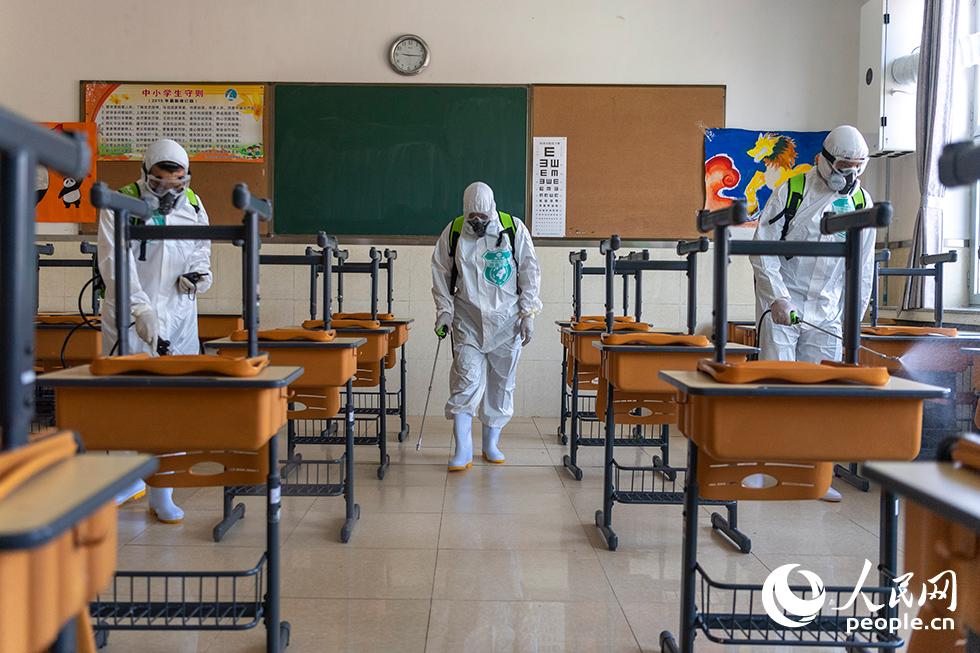 4月24日，消毒防疫人員正在噴洒生物酶制劑，對教室進行生物清潔。（人民網記者 翁奇羽 攝）
