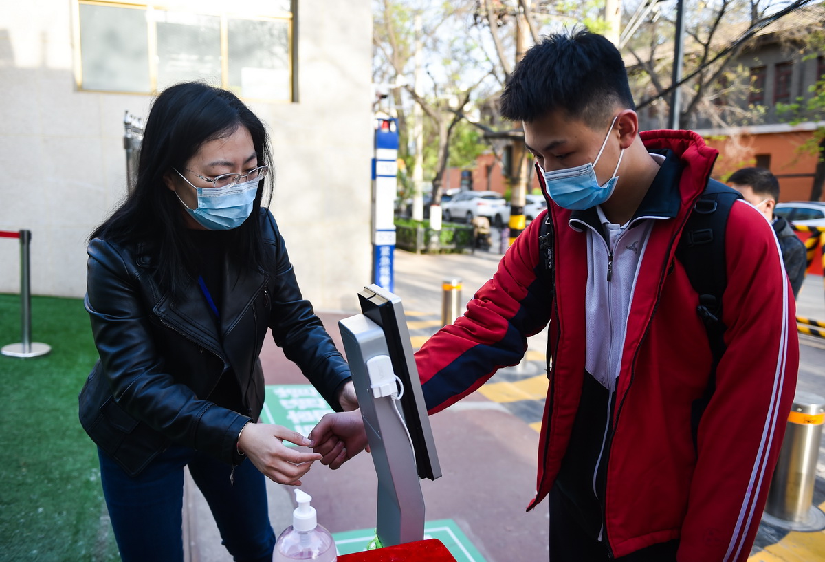 4月25日，在太原平民中學，學生在進校前接受體溫測量。