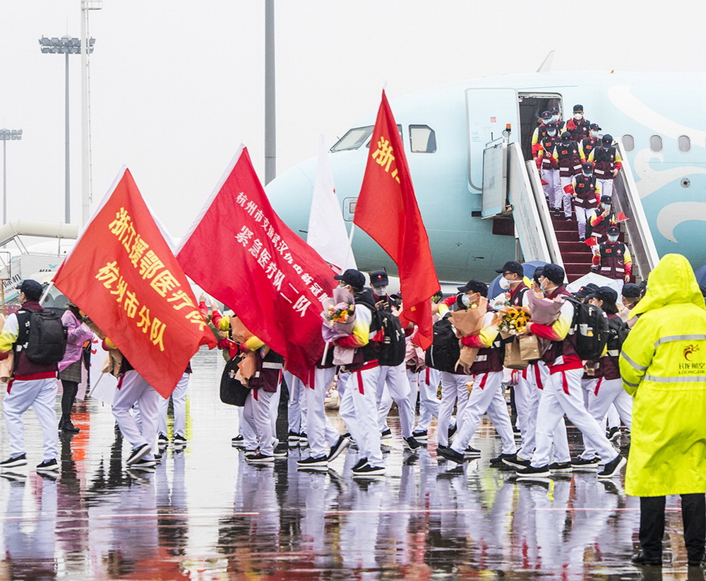 8.3月31日，杭州蕭山國際機場，醫療隊隊員手舉分隊隊旗，走下飛機。樓穎 攝
