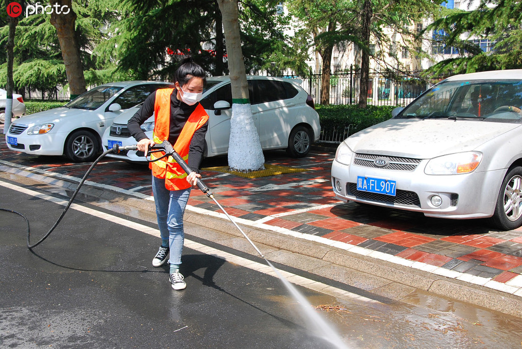 2020年5月1日，在河北省石家庄新乐市长寿路街头，一名环卫工人正在清洗街道。贾敏杰/IC photo