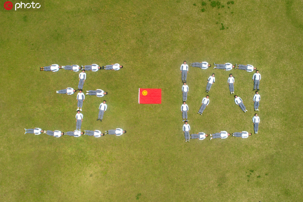 2020年5月2日，浙江省湖州市長興職教中心，青年學生在操場上擺出“五四”造型，與團旗合影。（無人機航拍）