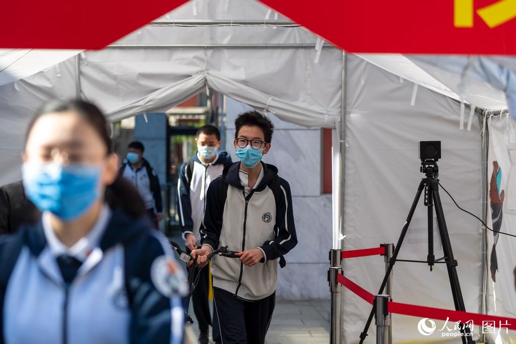 5月11日，在北京市第一六六中學，學生通過測溫棚后進入學校。（人民網記者 翁奇羽 攝）