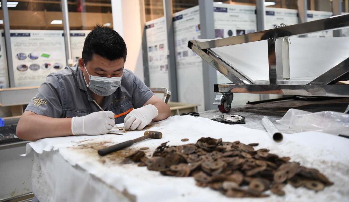 在广东阳江海陵岛，工作人员对“南海I号”上提取的古钱币进行清理（5月12日摄）。