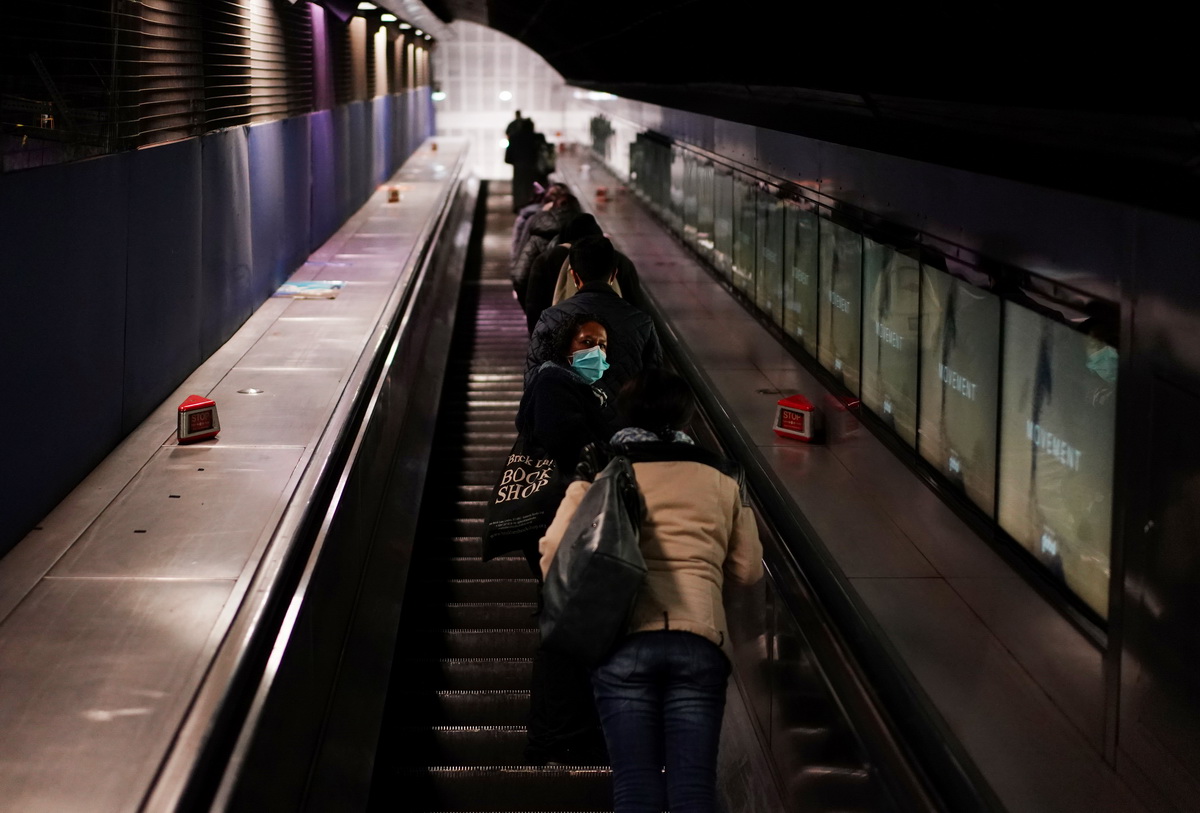这是5月14日在英国伦敦的一座地铁站拍摄的一名戴着口罩乘坐电梯的女子。