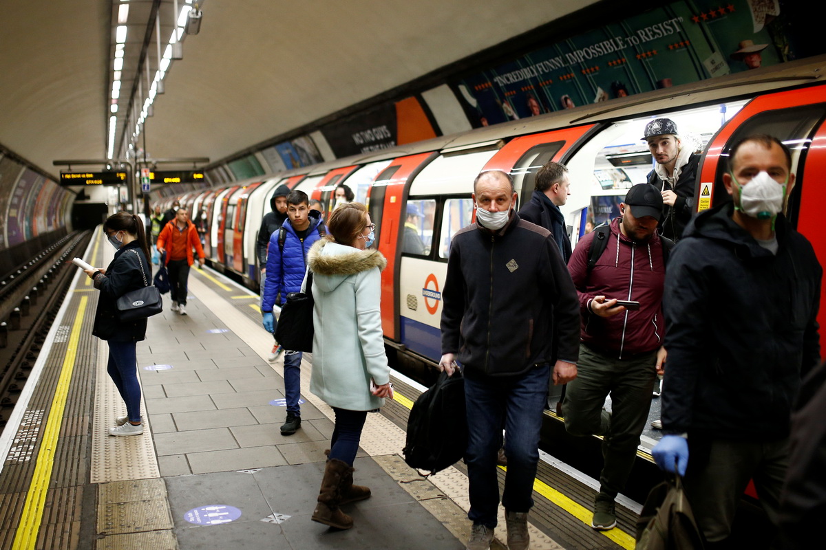 5月14日，在英国伦敦的一座地铁站，部分民众戴着口罩出行。