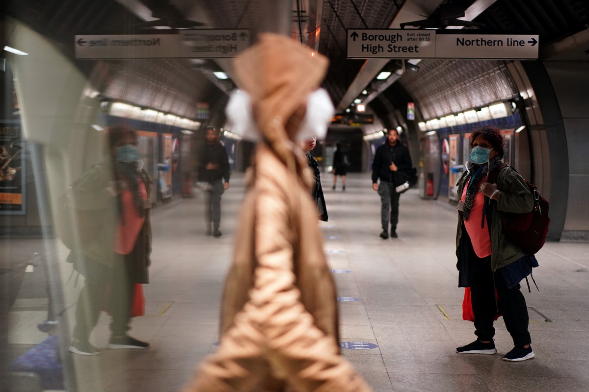 5月14日，在英国伦敦的一座地铁站，一名男子戴着口罩走出列车车厢。