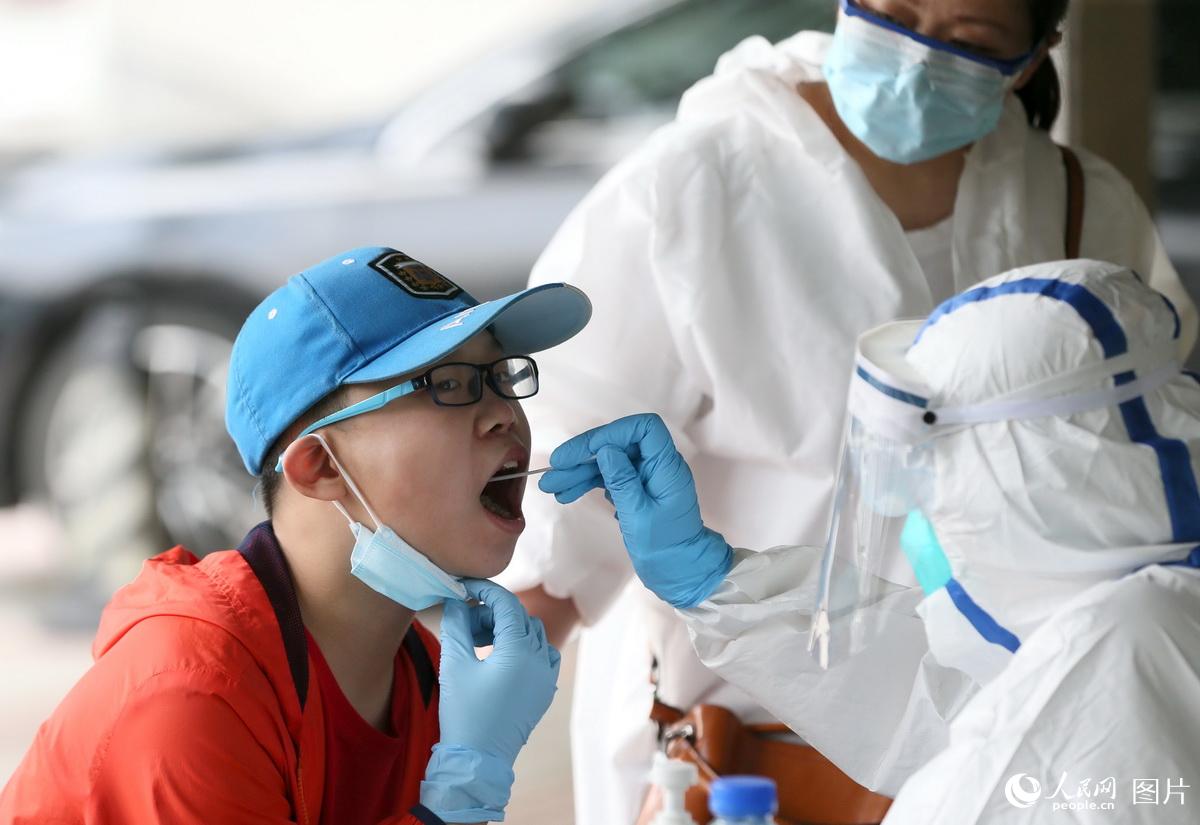 5月17日，勞動街惠中社區武漢晚報宿舍居民小區，武漢市第六醫院的醫護人員，為小區居民進行咽拭子核酸檢測。 