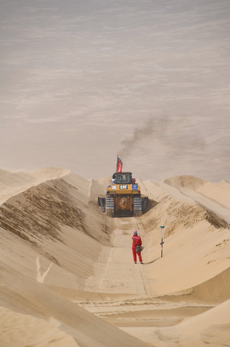 在新疆尉犁至且末沙漠公路施工现场，测绘员刘耀军在工作（5月17日摄）。