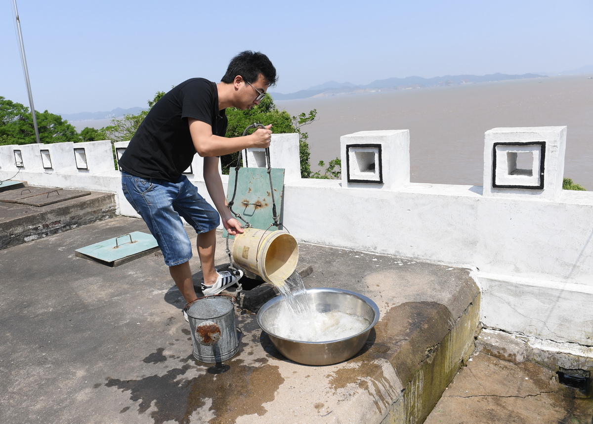 5月20日，在宁波七里屿，叶家第五代灯塔工叶超群从水窖内打水。为了克服淡水短缺的问题，灯塔工收集雨水存入水窖作为生活用水。