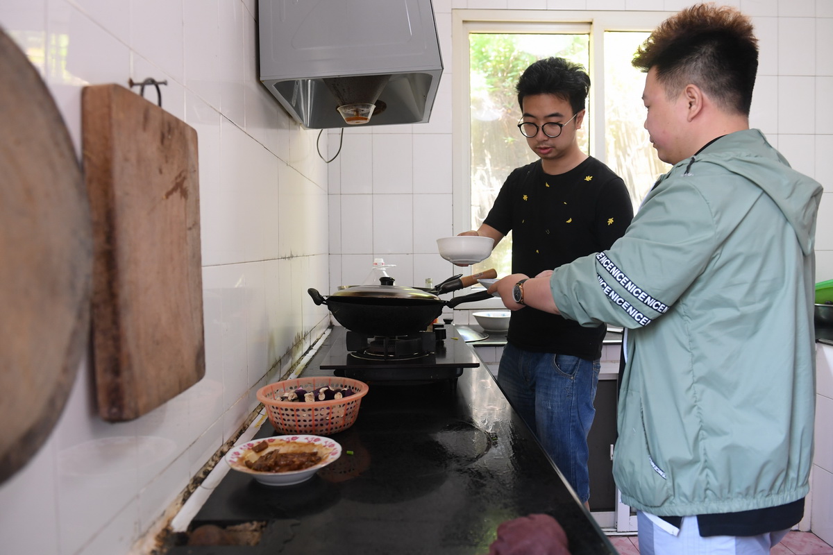 5月20日，在宁波七里屿，叶家第五代灯塔工叶超群（左）和同事叶露在厨房做饭。