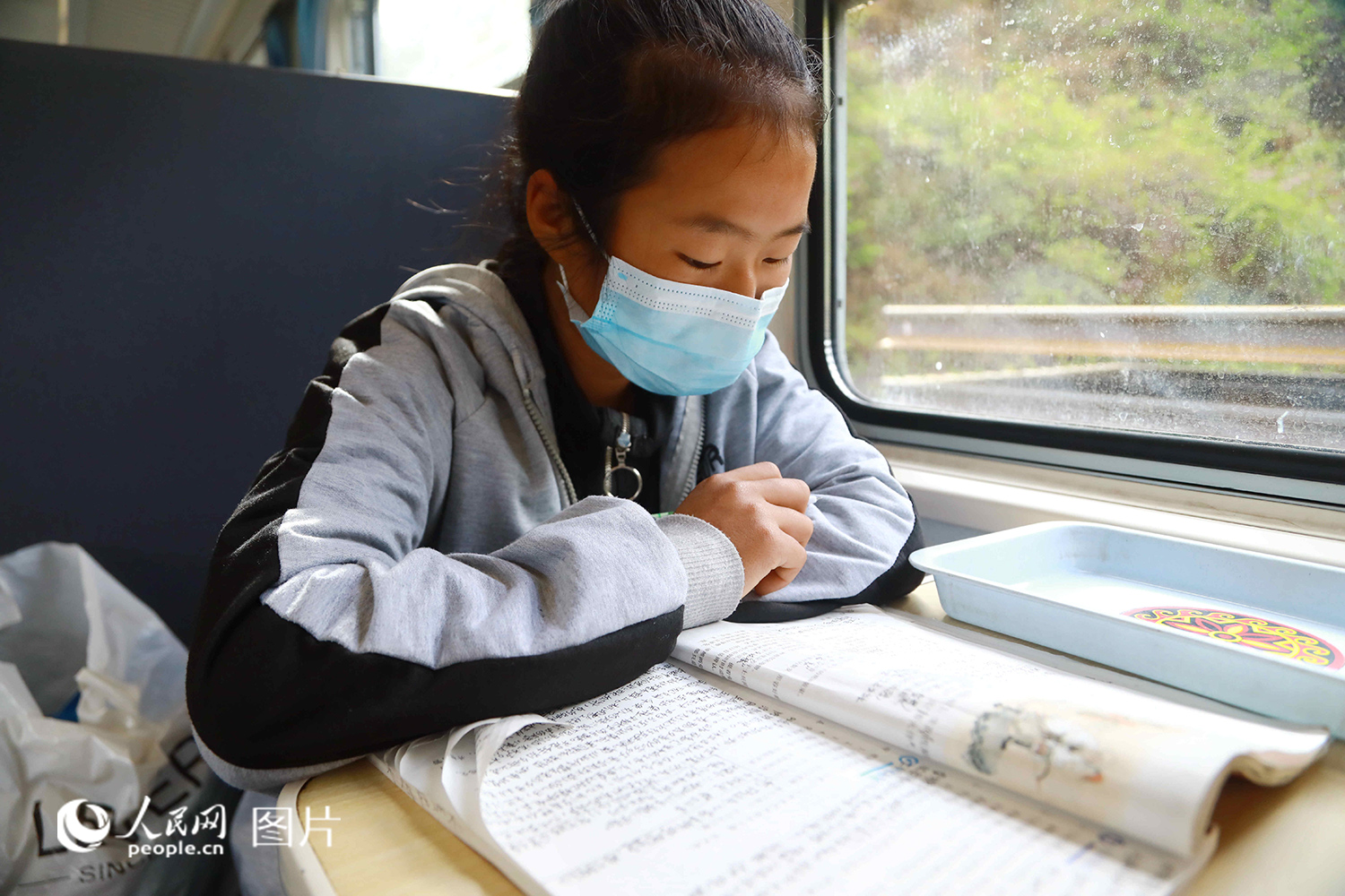 5633次列車上，一名彝族學生正在復習《木蘭辭》。（李鍇 攝）