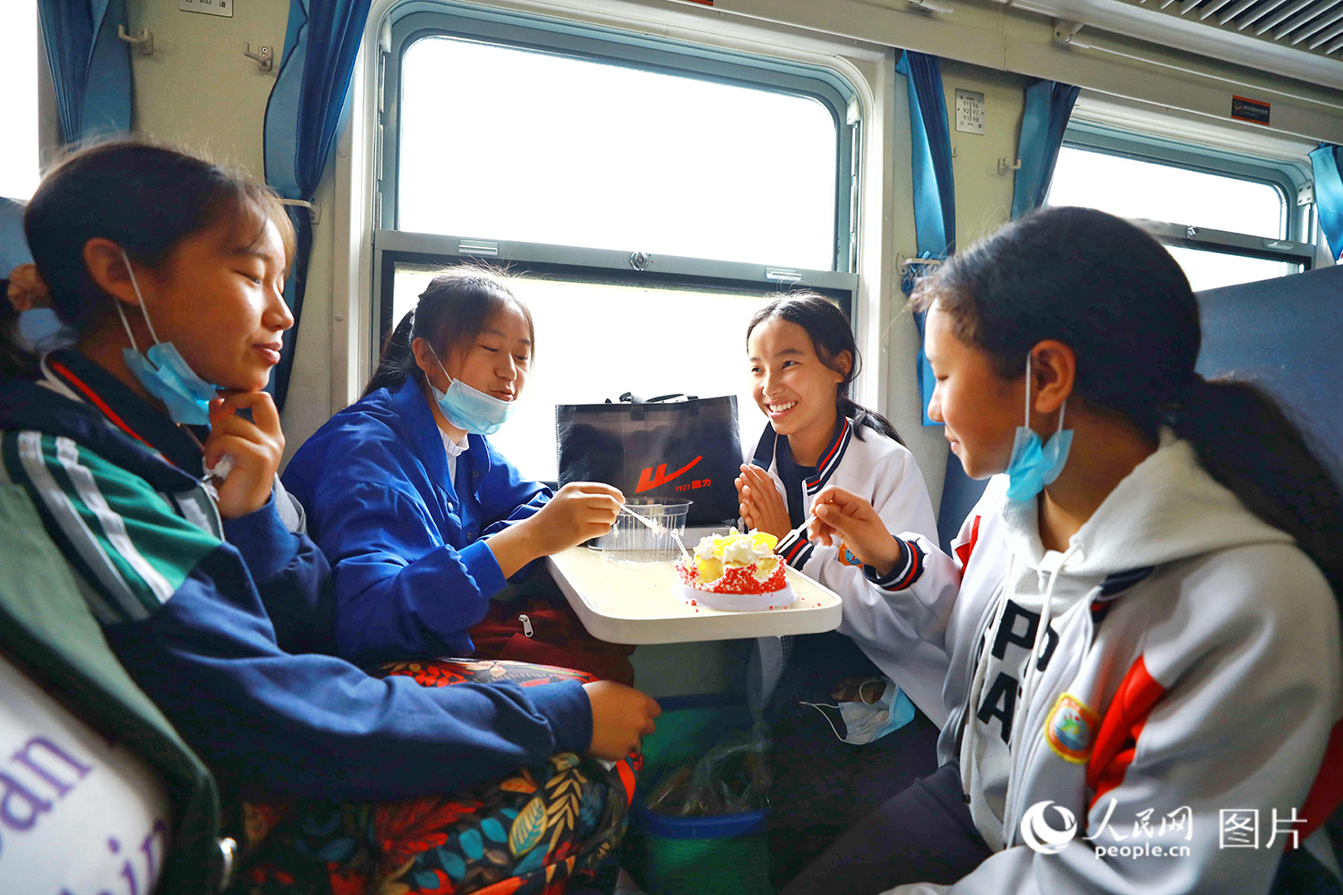 5633次列車上，小伙伴們為吉伍阿加（右二）精心准備了生日蛋糕。（李鍇 攝）