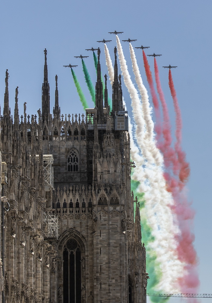 5月25日，意大利“三色箭”飛行表演隊噴出代表意大利國旗的三色彩煙，從意大利米蘭大教堂上空飛過。新華社/美聯