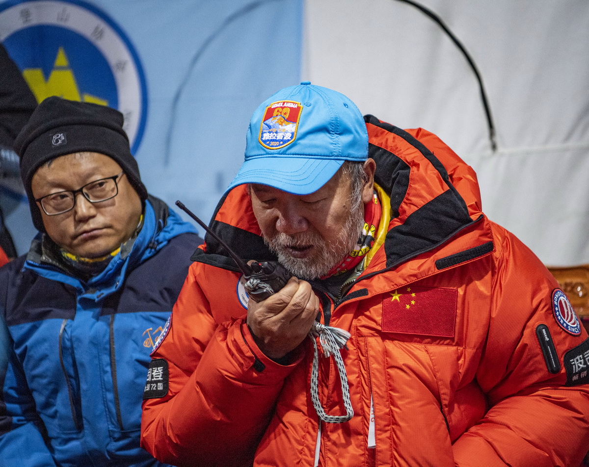 5月27日，在海拔5200米的珠峰大本營，2020珠峰高程測量登山隊總指揮、國家體育總局登山運動管理中心副主任王勇峰（右）正在和位於海拔8300米突擊營地的測量登山隊隊員通話。新華社記者 普布扎西 攝
