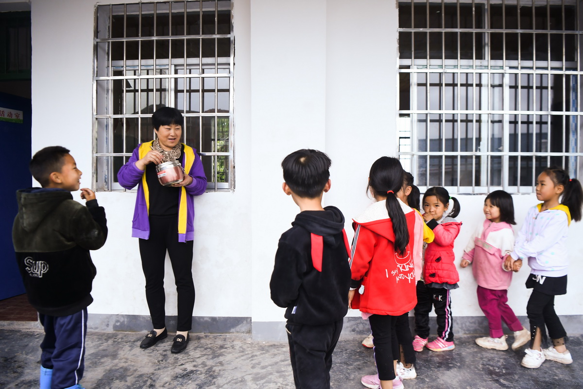 5月25日，為了保証學生們的安全，楊文清（左二）站在他們之間，邊看孩子邊吃午餐。