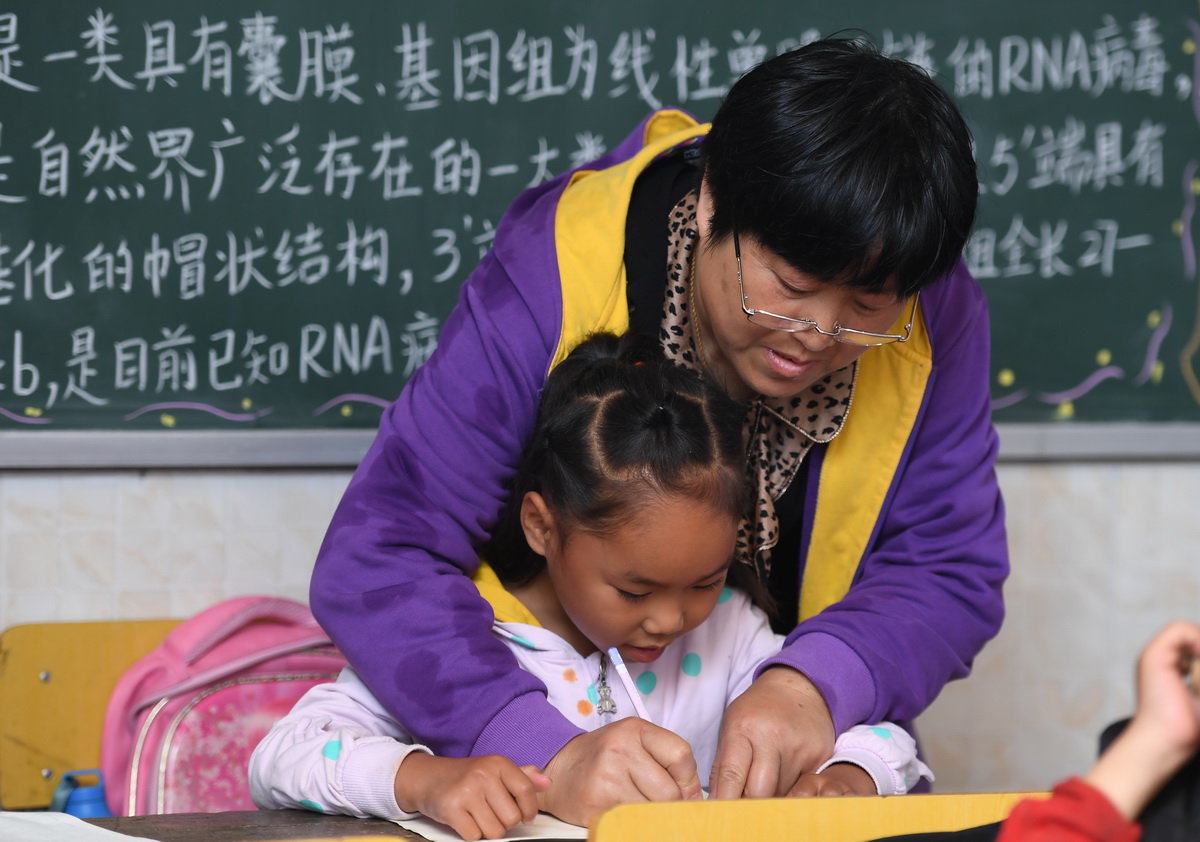 5月25日，楊文清在教學生寫字。