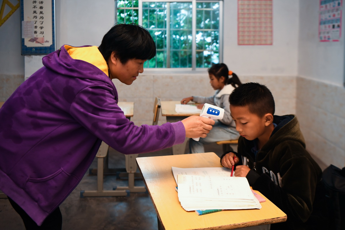 5月25日，楊文清（左）在早自習時為學生測量體溫。