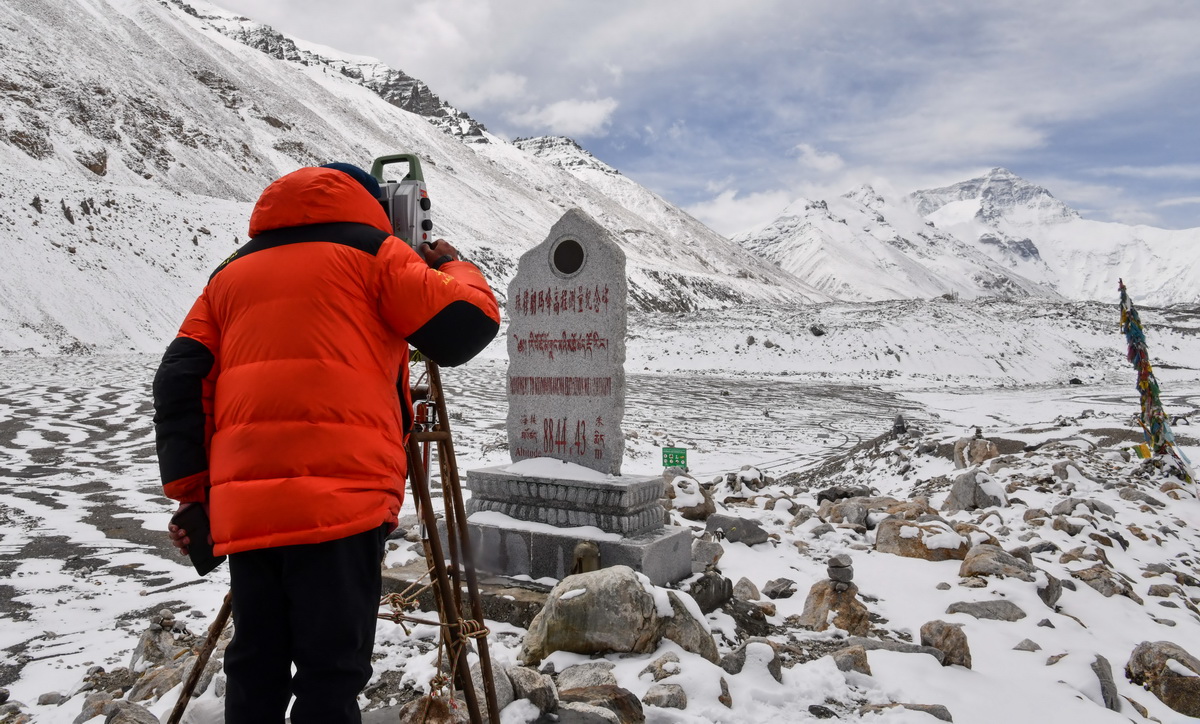 自然资源部第一大地测量队队员郑林在使用全站仪对珠峰峰顶进行交会观测（5月27日摄）。新华社记者 晋美多吉 摄