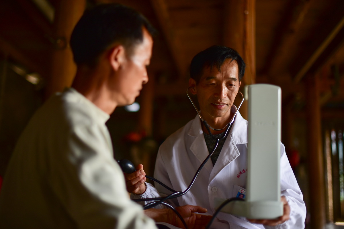 5月27日，村醫龍光慶（右）為雙堯村村民楊勝良測量血壓。