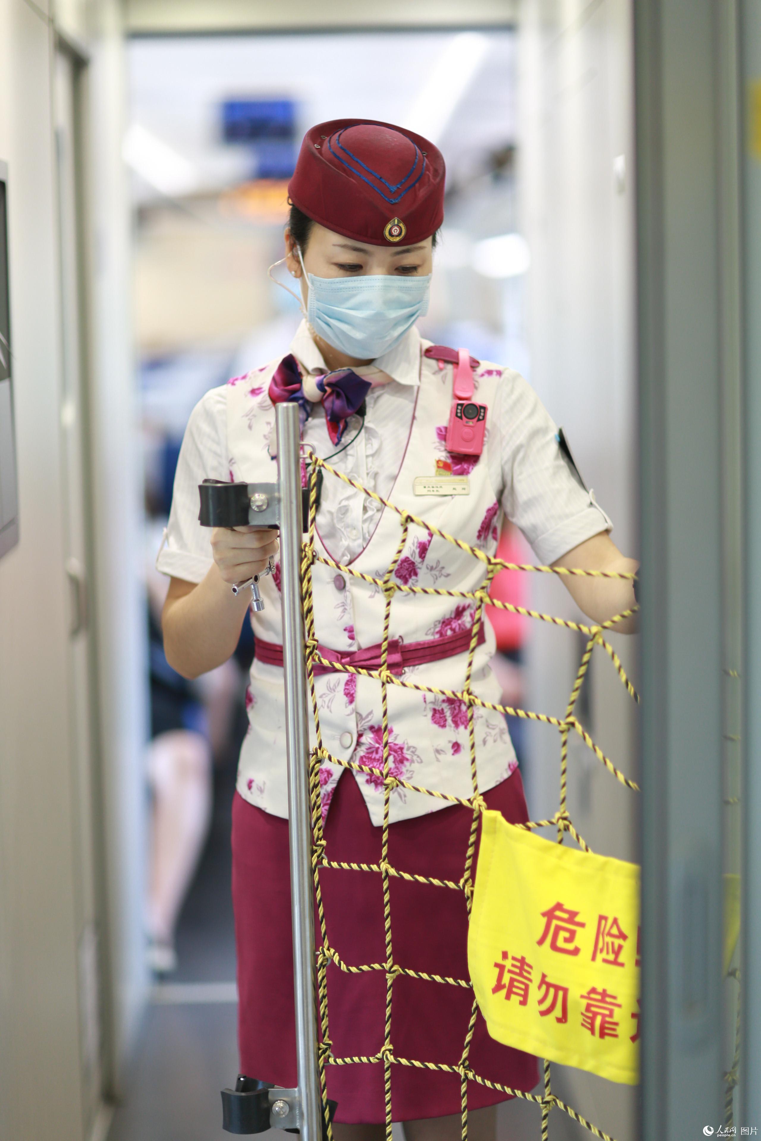 2020年5月29日，G8508次列車上，趙玲對列車防護網進行整理檢查。