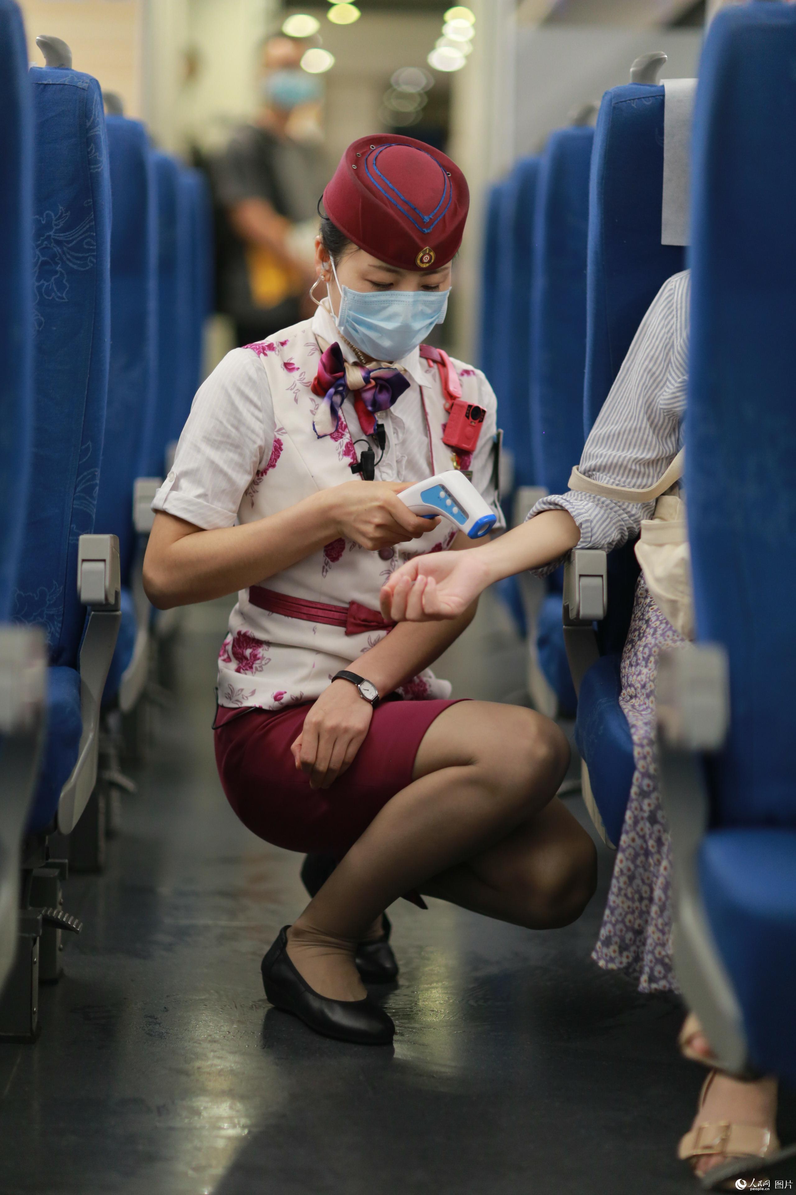 2020年5月29日，G8508次列車上，趙玲為旅客測溫。