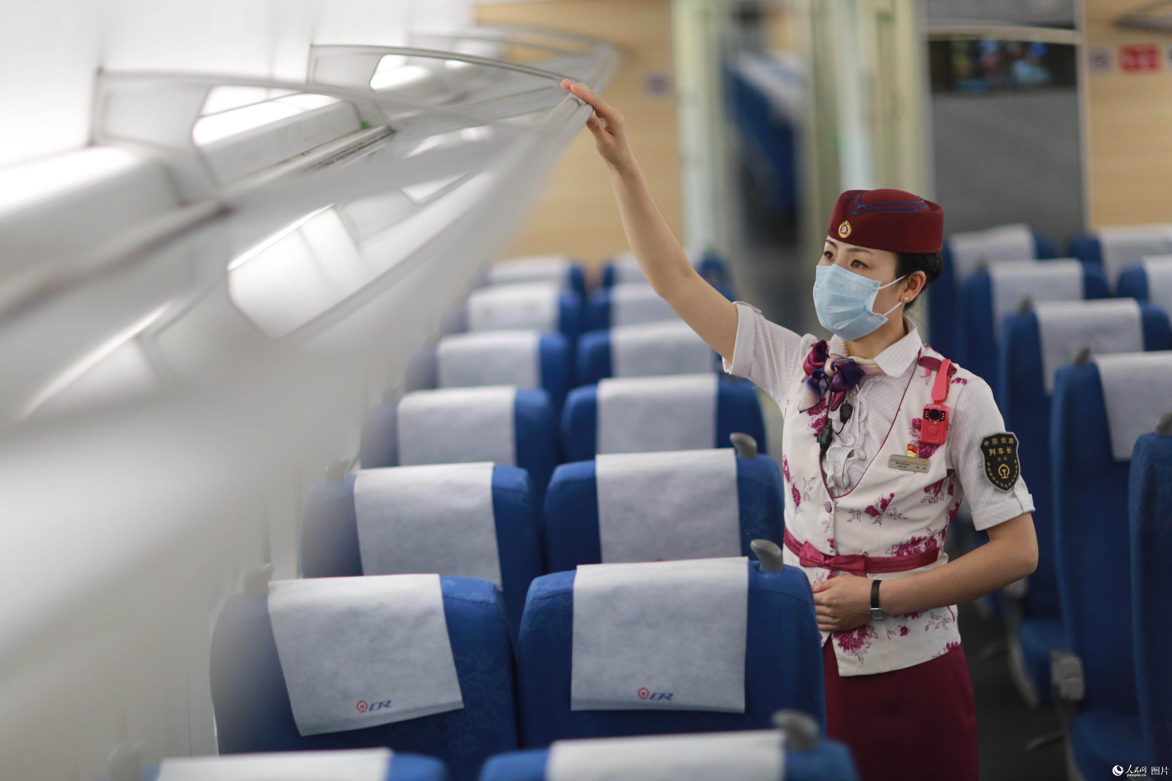 2020年5月29日，G8511次列車抵達重慶北站，趙玲對車廂的行李架進行檢查。