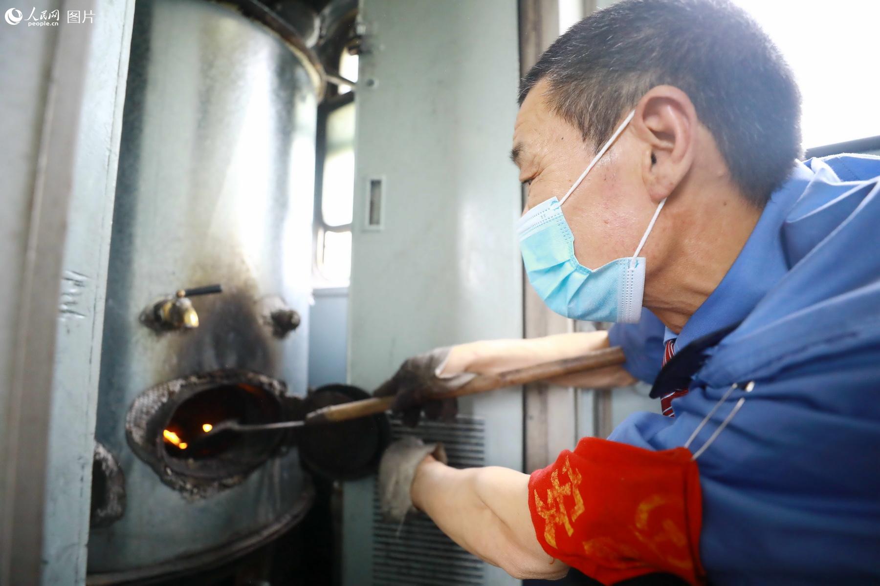 5月21日，5633次列車供水員王青海，正在檢查燃煤茶爐。（李鍇 攝）
