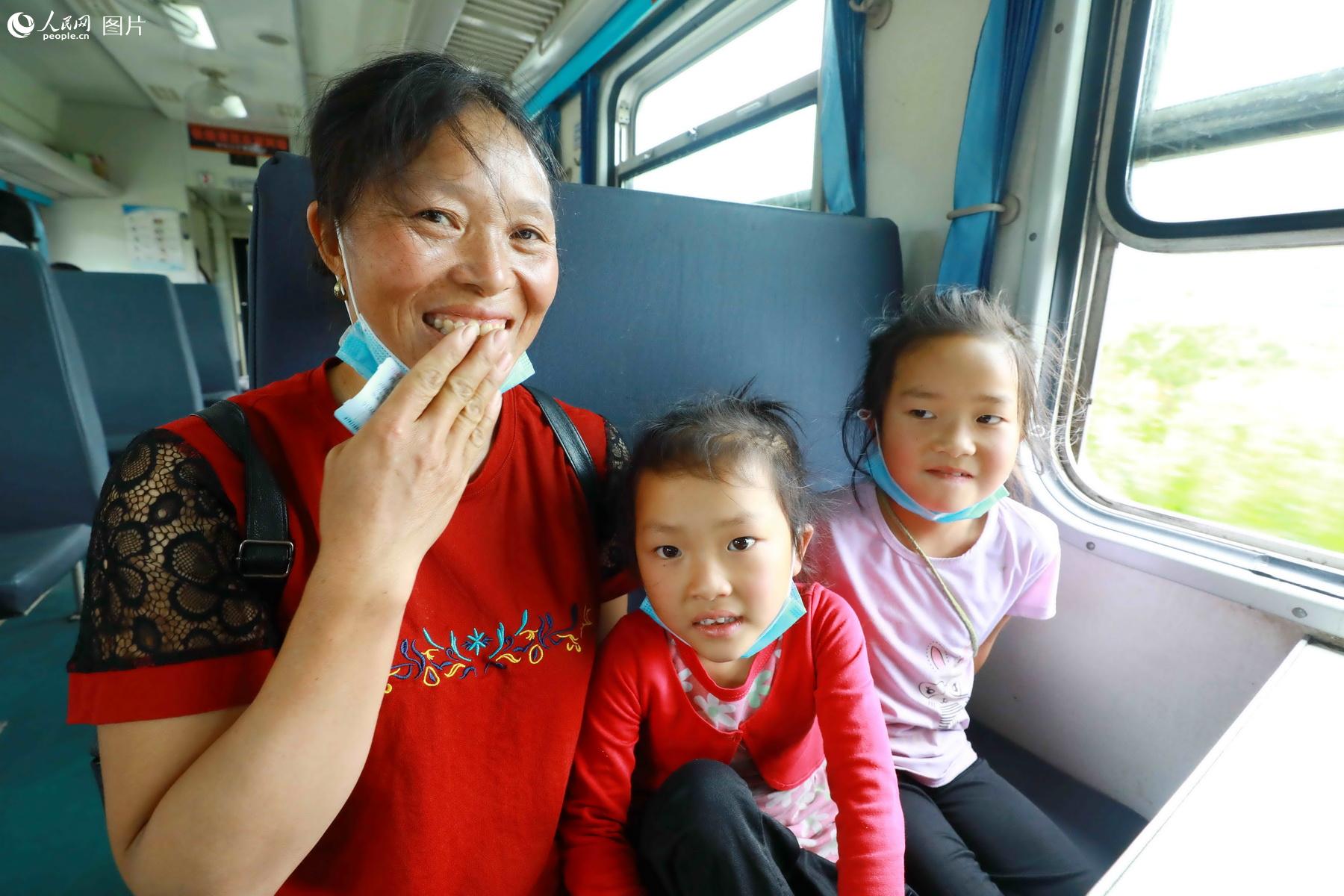 5月21日，蘇克的莫（左一）帶著兩個女兒阿合小花（右一）和阿合金學（中間），乘坐5633次列車前往德昌。（李鍇 攝）