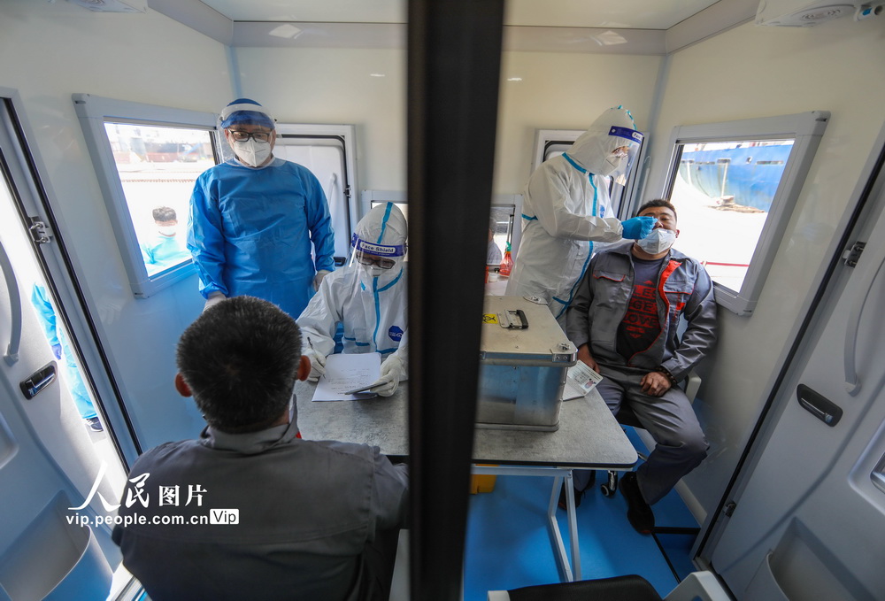 6月9日，海關工作人員在口岸檢疫方艙內對船員進行流行病學調查和核酸樣本採集等工作。
