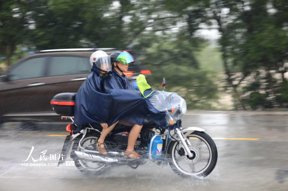6月10日，在G209國道廣西柳州市融安縣長安鎮紅衛村段，市民駕駛摩托車在雨中出行。
