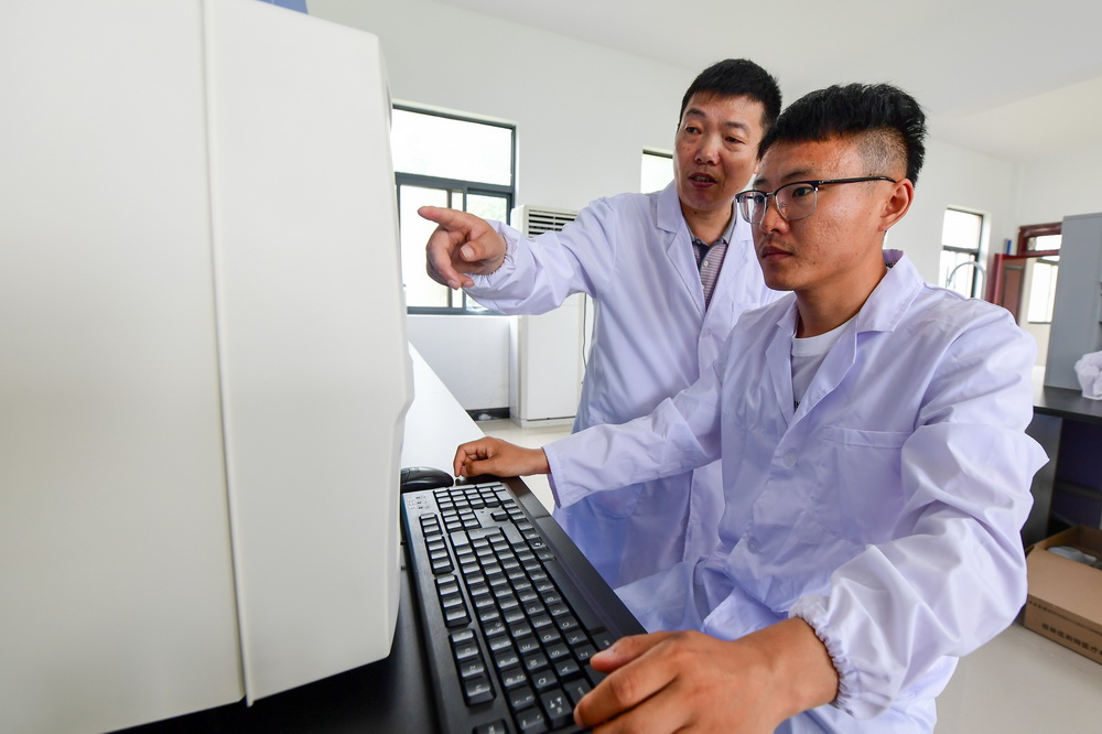 6月11日，任義軍（左）和同事俞曉鵬在保護區實驗室對鹿血進行分析。