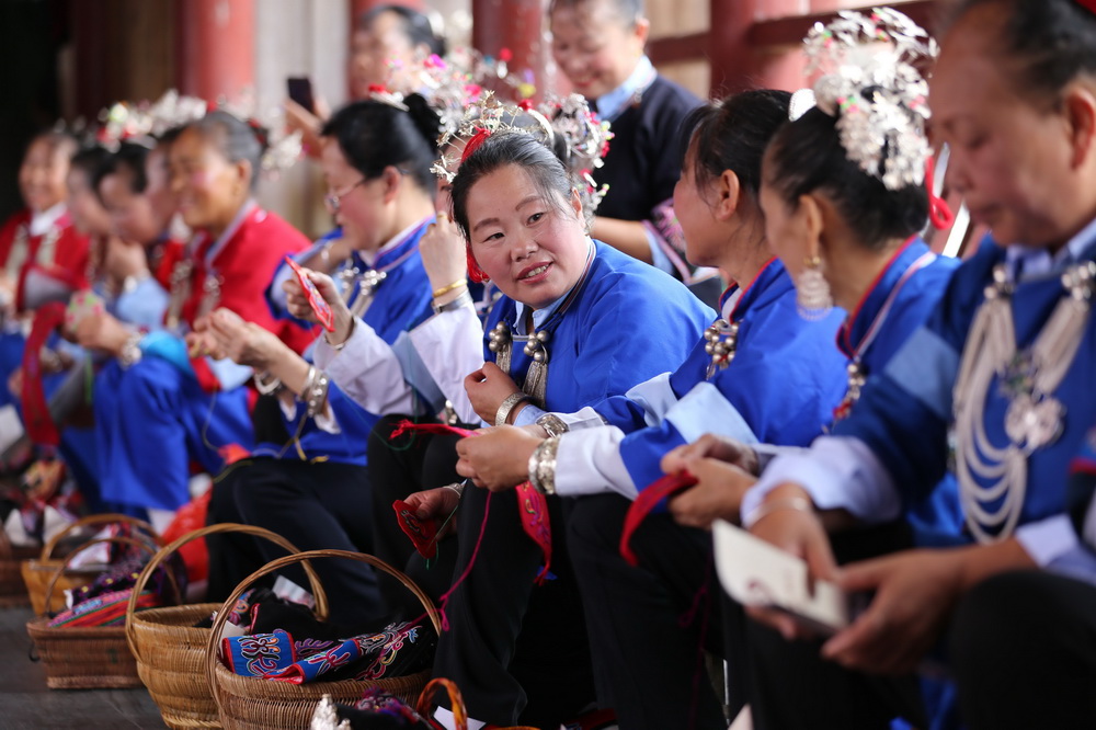 6月11日，繡娘們在貴州省錦屏縣三江鎮赤溪坪風雨橋進行刺繡技藝展示。
