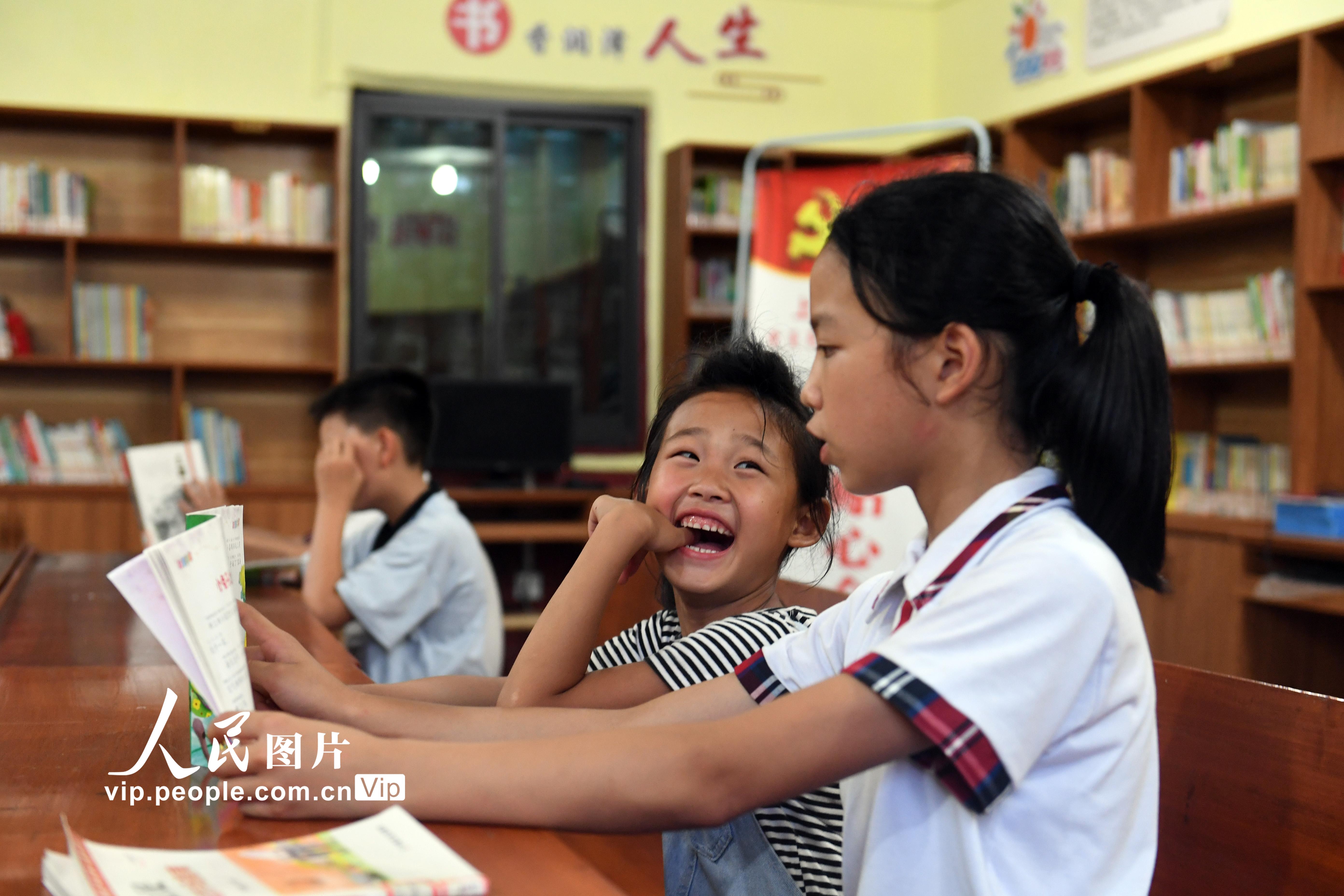 2020年6月15日，江西省上栗縣金山鎮高山村的四點半課堂裡，4年級的邱鑫怡（右一）給王柯讀童話。陳剛/人民圖片