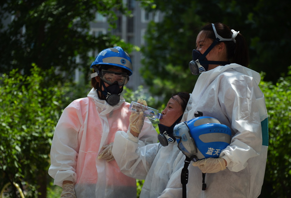 6月16日，北京藍天救援隊隊員在完成對豐台區一居民區消殺作業后休息。