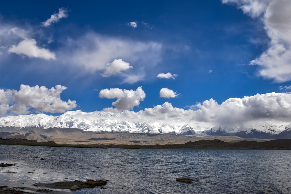帕米爾高原上喀拉庫勒湖畔連綿的雪山（6月16日攝）。新華社記者 高晗 攝