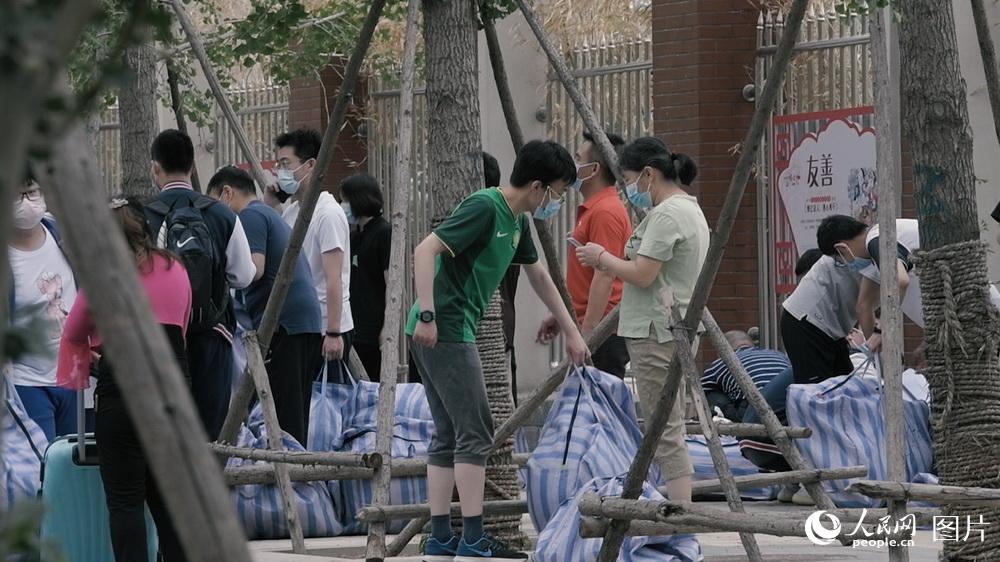 6月17日上午，北京某中學門前，即將離校的學生正在領取自己的行李物品。人民網記者 王嘉澍 攝