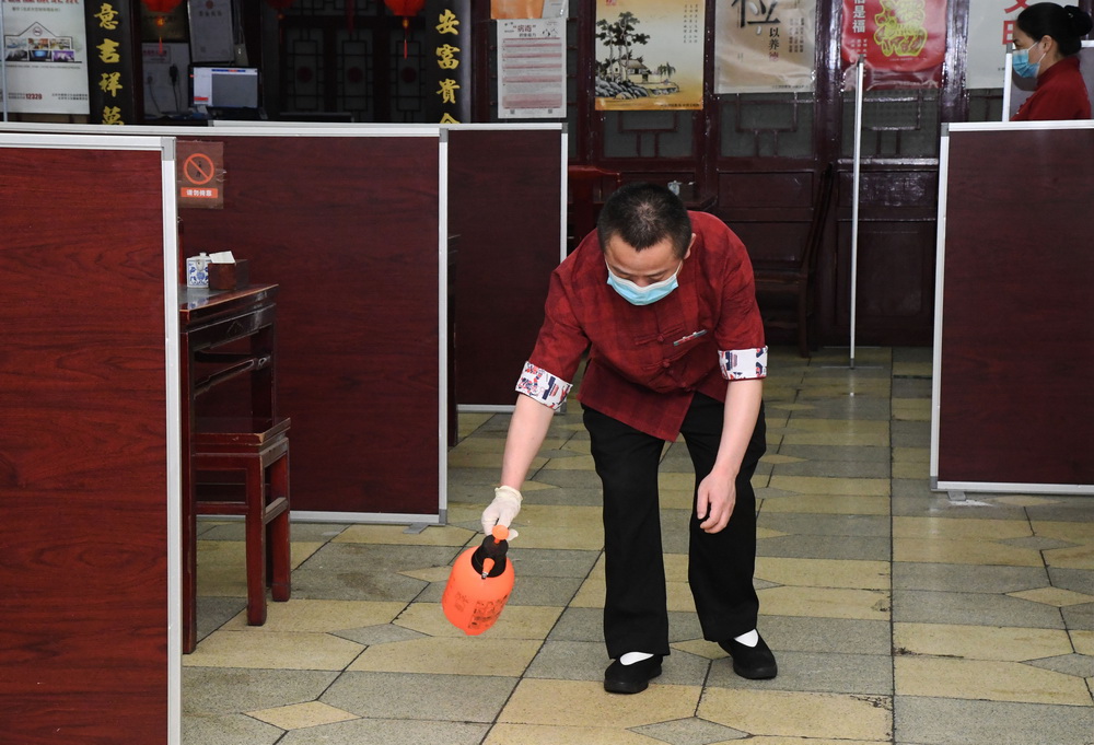 6月17日，在位於北京市海澱區的海碗居增光路店，工作人員對地面進行消毒。