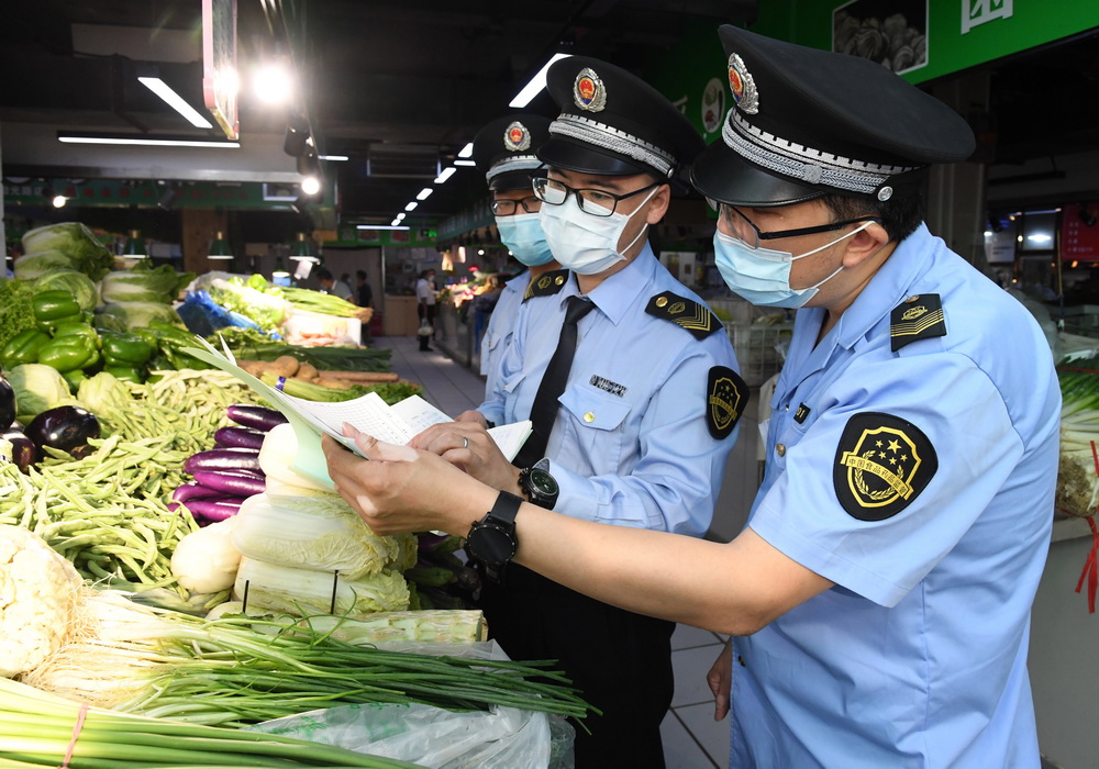 6月17日，在位於北京市海澱區的增光鴻運市場，執法人員對商戶所售蔬菜的進貨渠道進行檢查。