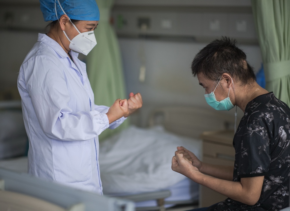 6月17日，醫生朱琦在病房指導胡定江進行恢復訓練。
