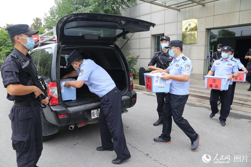 6月19日，在全副武裝的特警護衛下，緝毒民警將封存的一箱箱毒品轉移至押運車。