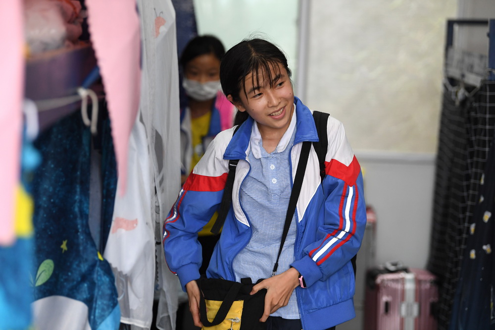 6月19日，在金寨縣三合實驗學校宿舍，蔡齊艷放學后收拾行李准備回家過周末 。