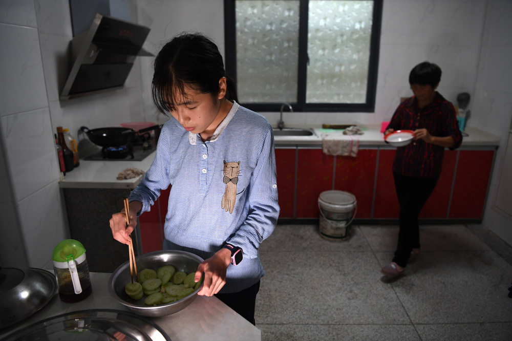6月19日，蔡齊艷在家裡幫媽媽准備晚餐。