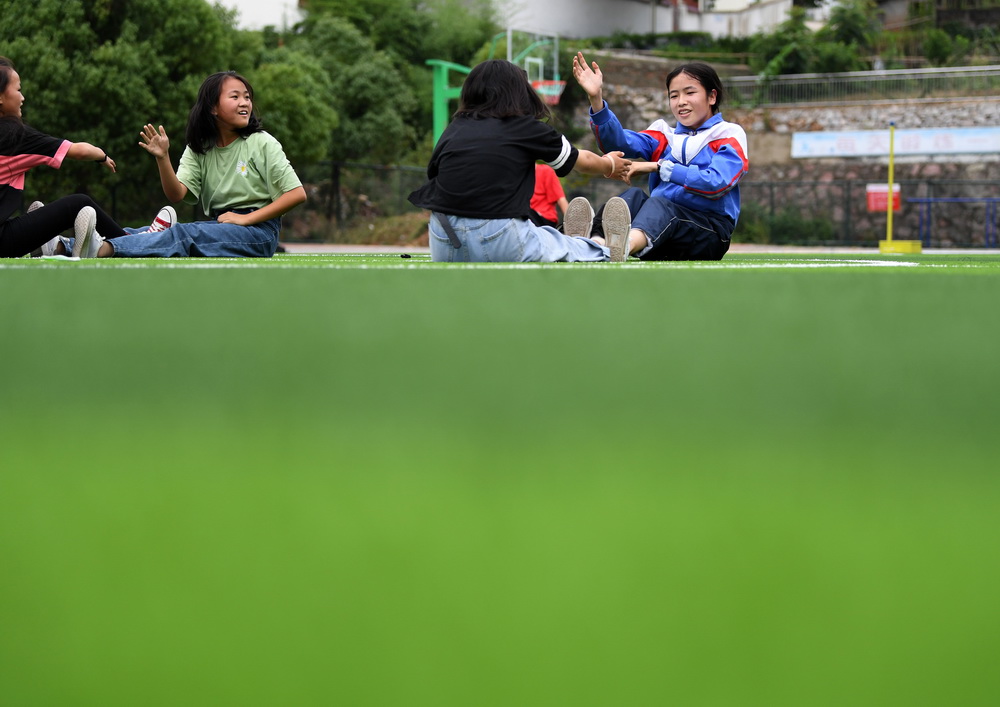 6月19日，在金寨縣三合實驗學校，蔡齊艷（右一）和同學一起在體育課上做小游戲。