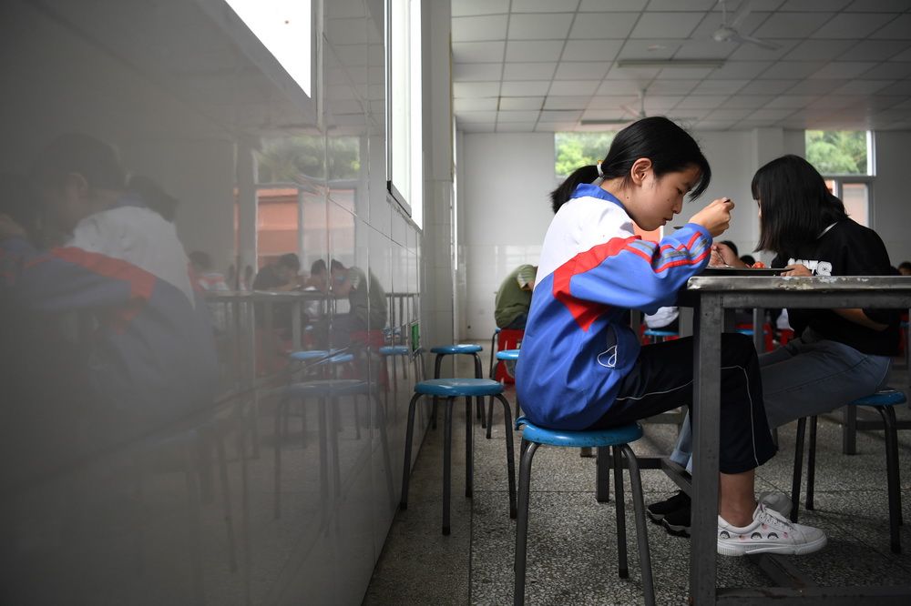 6月19日，在金寨縣三合實驗學校，蔡齊艷和同學一起吃午飯。