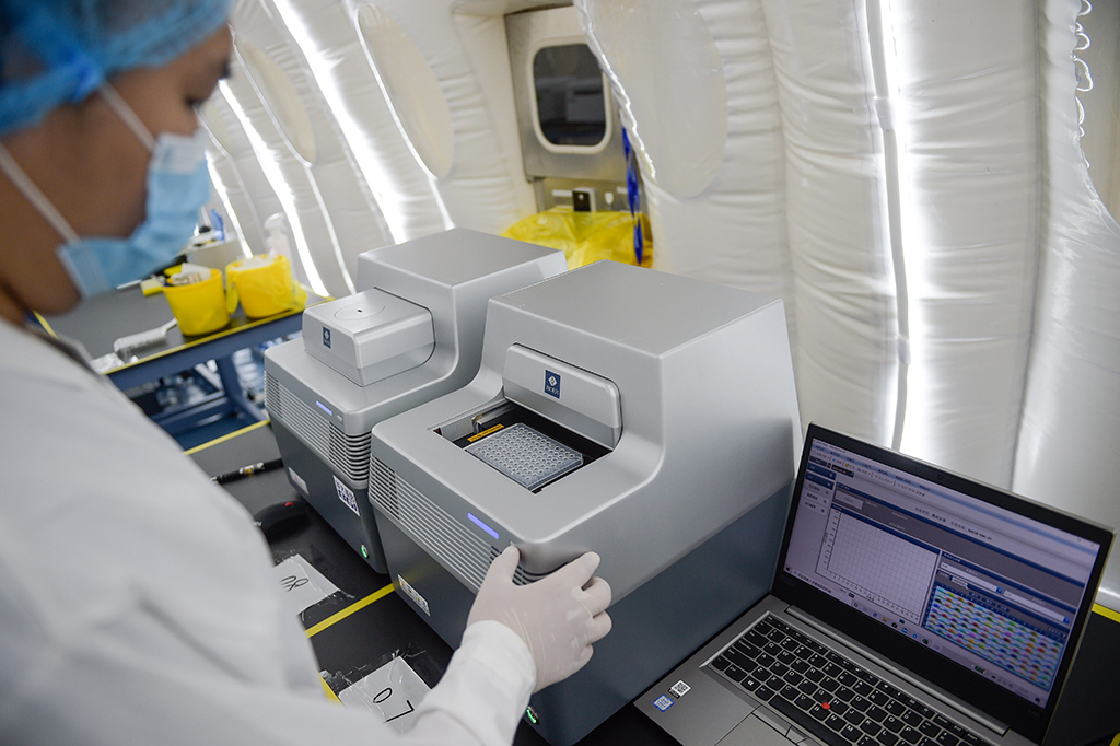7月1日，在擴增實驗室內，實驗人員將核酸反應板放入PCR儀中做熒光反應檢測。新華社記者 彭子洋 攝