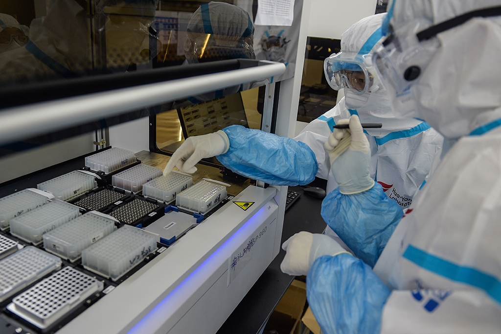7月1日，在提取實驗室內，實驗人員將樣本板放入自動提取儀后核對樣本板和試劑板位置。 新華社記者 彭子洋 攝