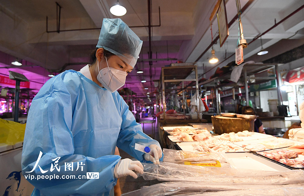 7月1日，貴陽市南明區疾病預防控制中心工作人員正在對貴陽市萬東農貿市場內售賣的凍帶魚進行核酸採樣。