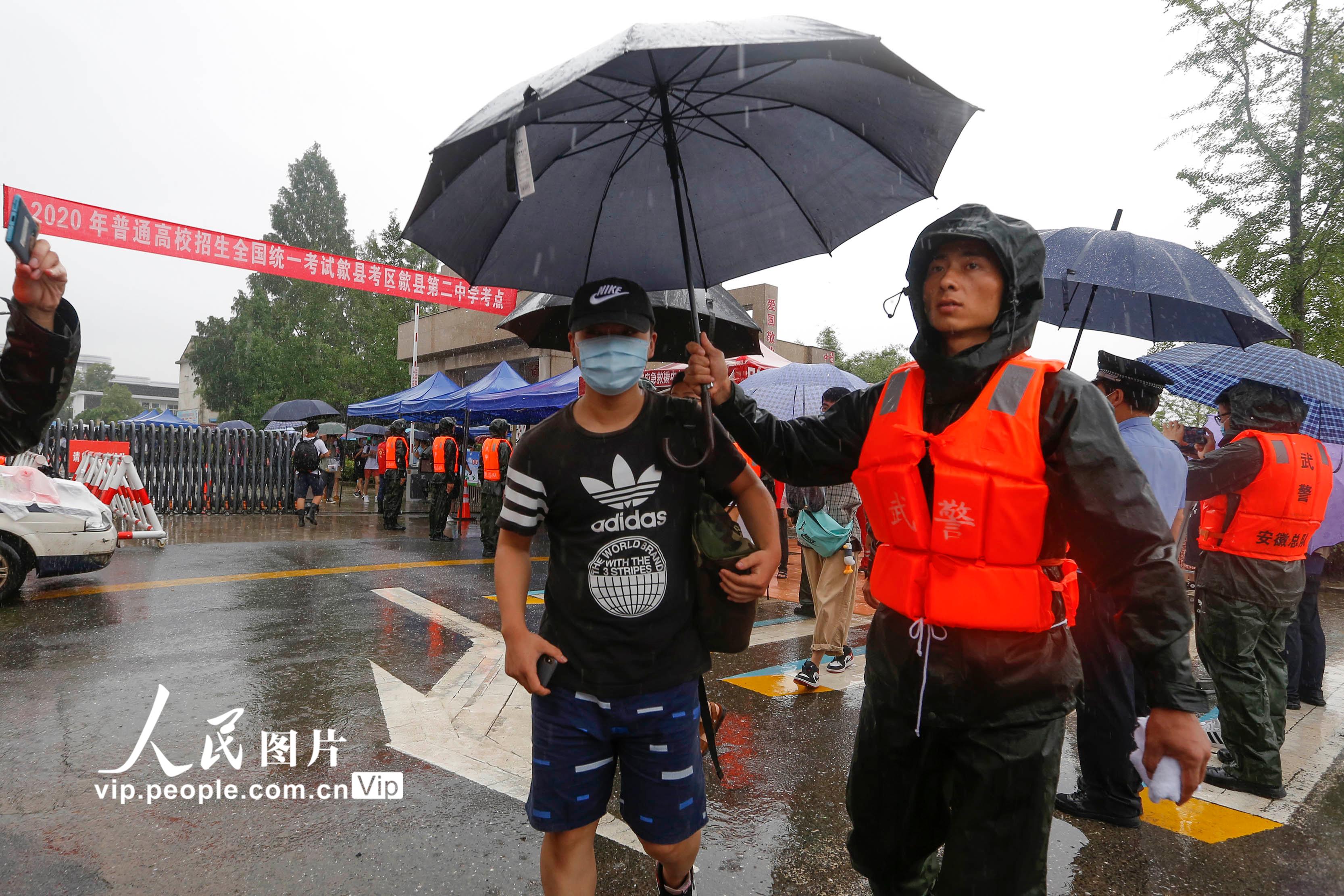2020年7月8日，安徽省黃山市歙縣二中考點，武警官兵雨中護送考生。施亞磊/人民圖片