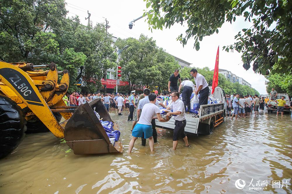 2020年7月10日，在江西省吉安市峽江縣水邊鎮，黨員干部在運送抗洪救災物資。