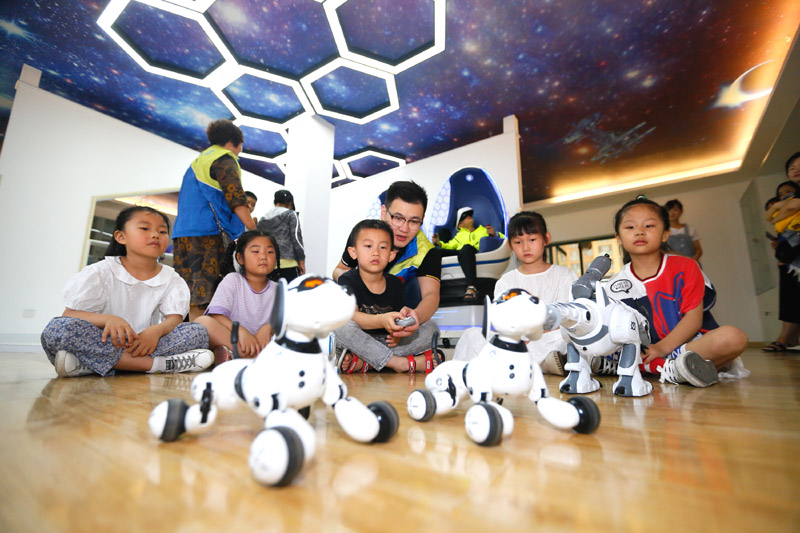 7月12日，小學生在山東省青島市即墨區環秀街道濱湖社區科普館觀看機器狗表演。